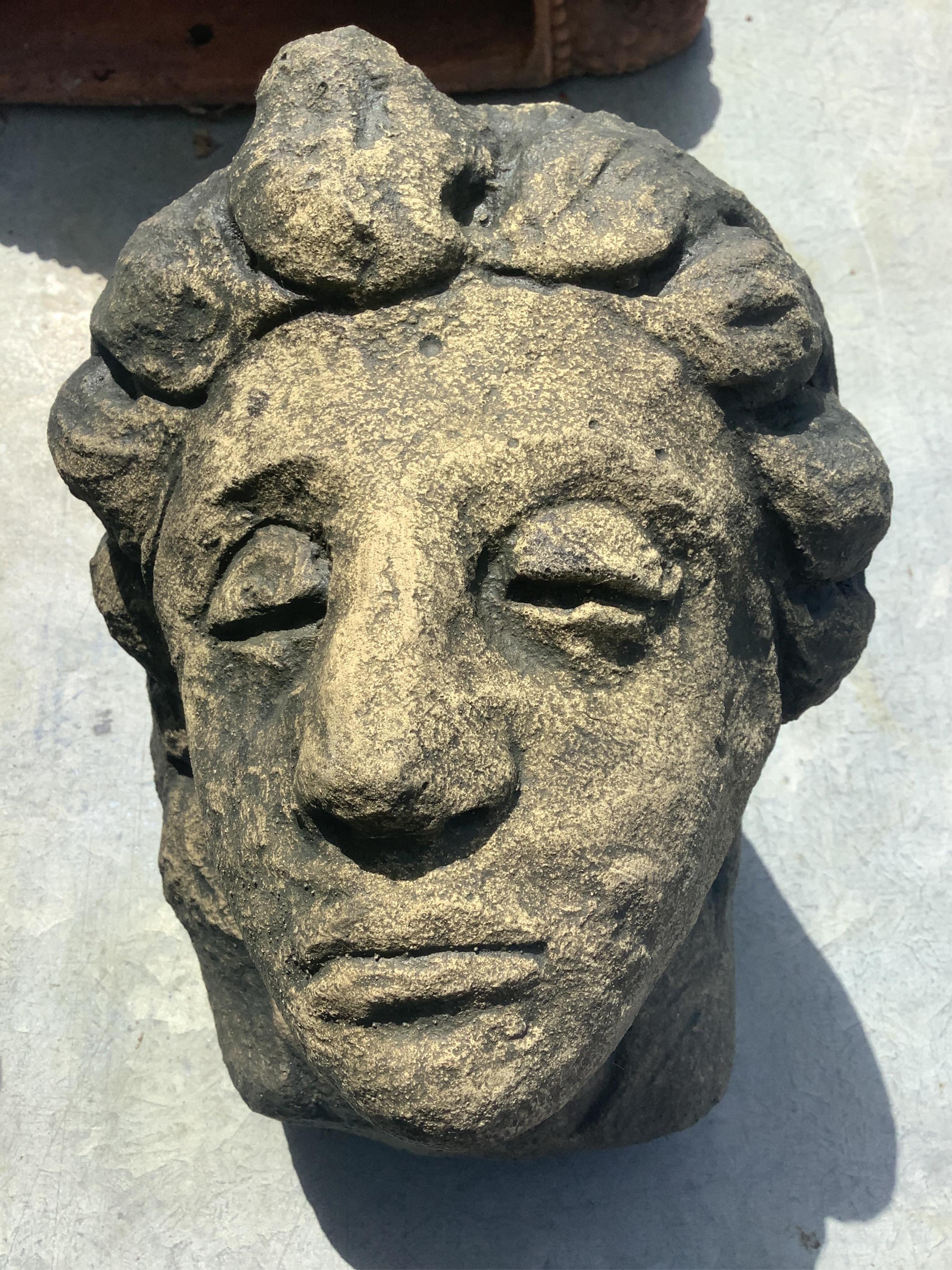 A pair of cast stone mask corbels, height 21cm